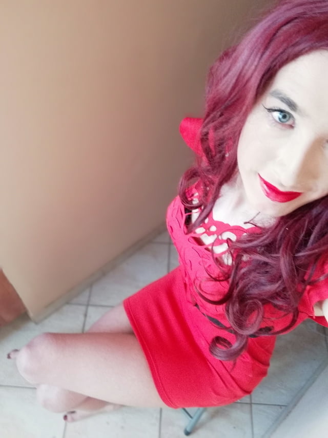Hermosos ojos de chica transexual pelirroja en vestido rojo