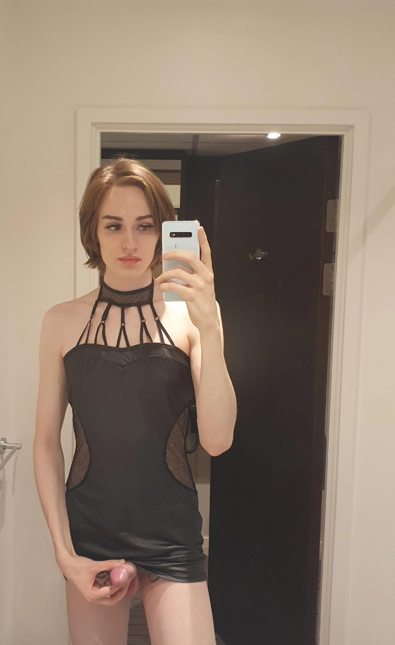 Guapa transexual en minivestido se toma una selfie mostrando su verga